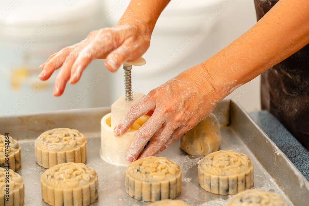 Mooncake making process. A mooncake  is a Chinese bakery product traditionally eaten during the Mid-Autumn Festival.