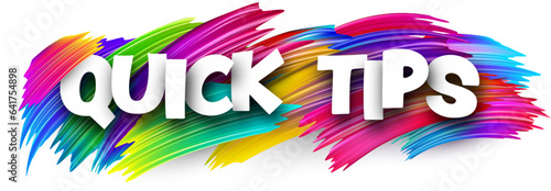 Quick tips paper word sign with colorful spectrum paint brush strokes over white.