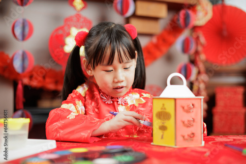 young girl with traditional dressing up celebrating Chinese new year against all kind of " FU" means" lucky" ornament and greeting card background