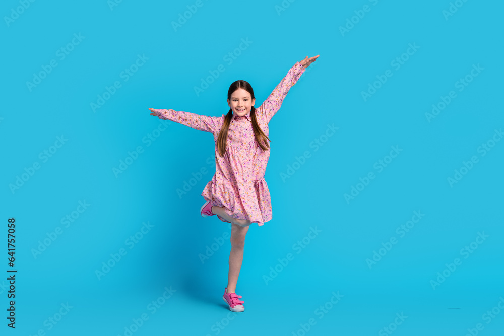 Full body size photo of funny daughter jumping hands up flying air wings careless wear pink dress isolated on blue color background