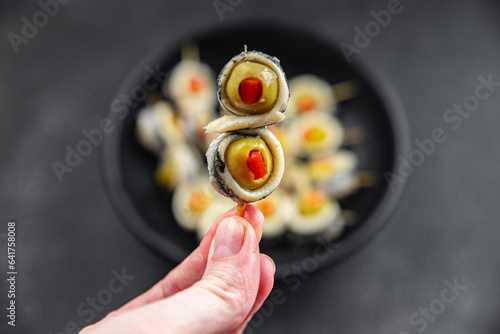 olive stuffed anchovy fillets, anchovy roll stuffed olives apetizing seafood pickled fish marinated ready to eat appetizer meal food snack on the table copy space food background rustic top