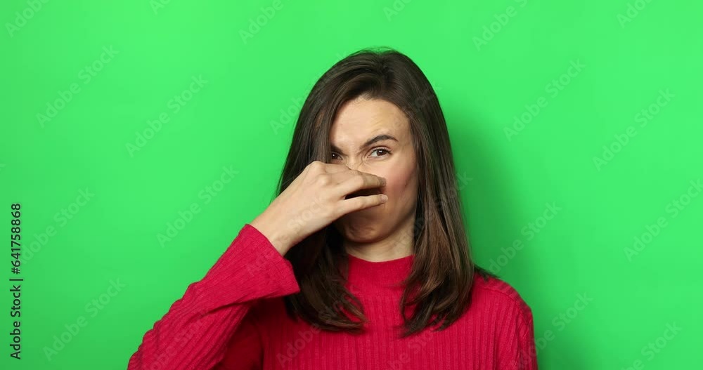 Disgusting odor. Discontent caucasian woman frowning face, smells something awful, feeling aversion, green chroma key studio background. Disgusting odor. Discontent caucasian woman frowning face, smells something awful, feeling aversion, green chroma key studio background.