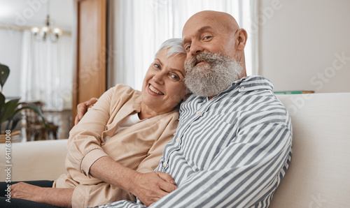 Smile, portrait and senior couple on a sofa in the living room of modern home for bonding. Happy, love and elderly man and woman in retirement hugging and relaxing together in the lounge of a house.