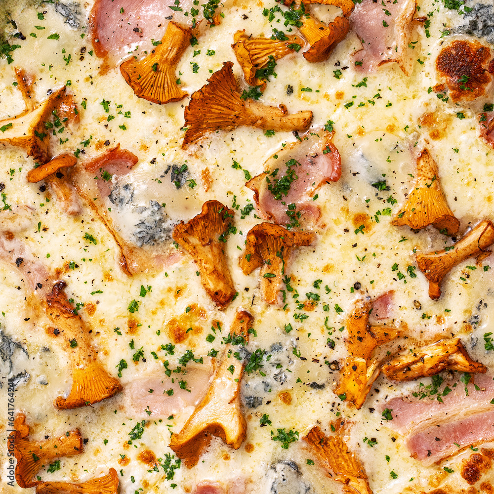 Close-up of pizza filling and texture, chanterelle mushrooms, ham and blue cheese on top