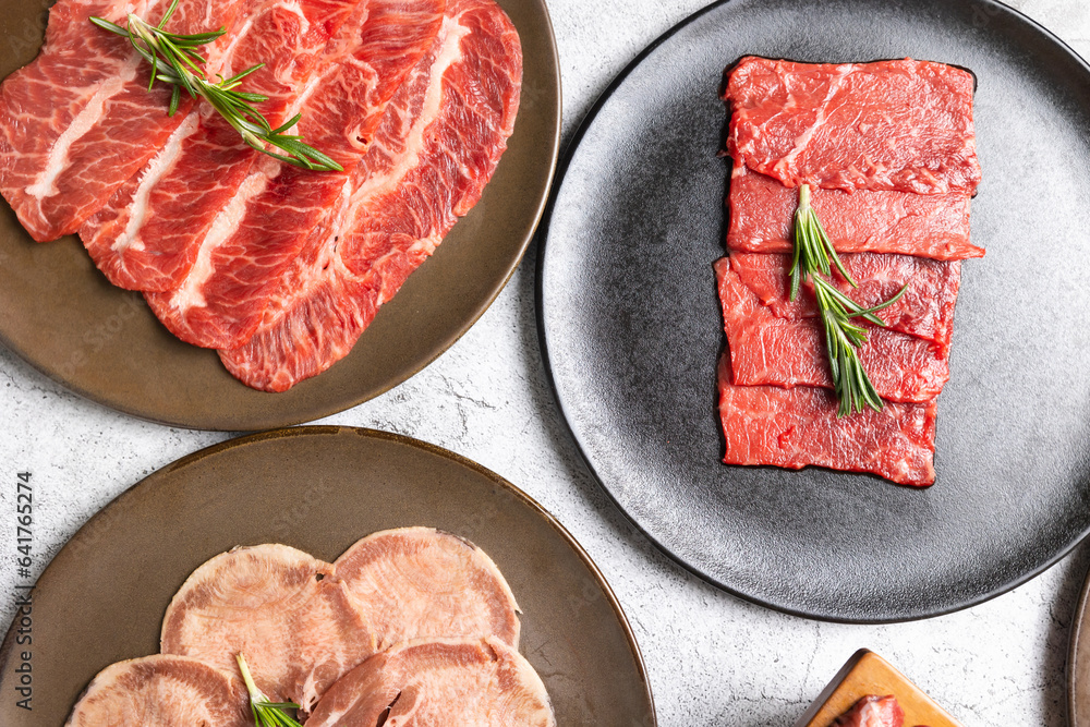 Japanese and korean food isolated on gray stone banner background Top view Variety Fresh raw beef steaks on plate for grilling. hot pepper and herbs