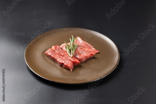 Rare Sliced Wagyu beef with marbled texture. Japanese and korean rare beef for grilled on black plate food isolated on gray stone banner background