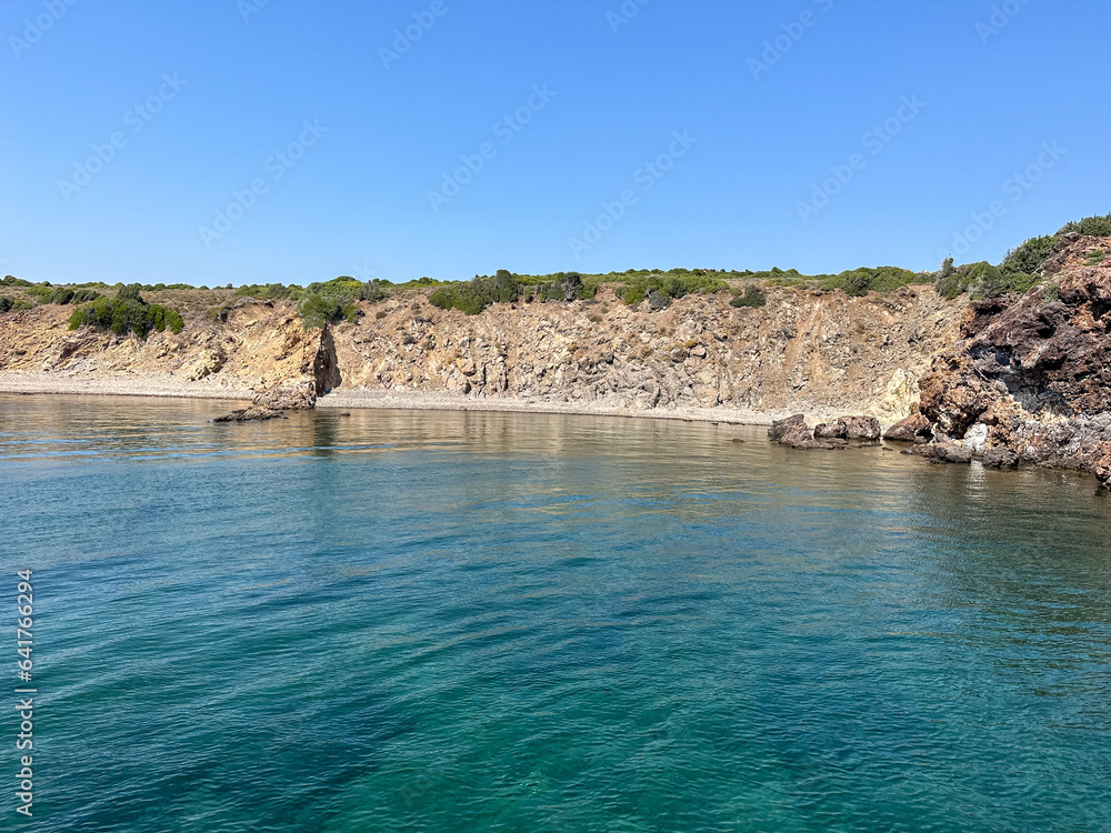 Aegean sea near Ayvalik, Cunda. Sea side summer holidays. Charming bay near Cunda island in Aegean sea, crystal clear water surrounded by rocks. Blue sky, turquoise blue water, vacations, summertime