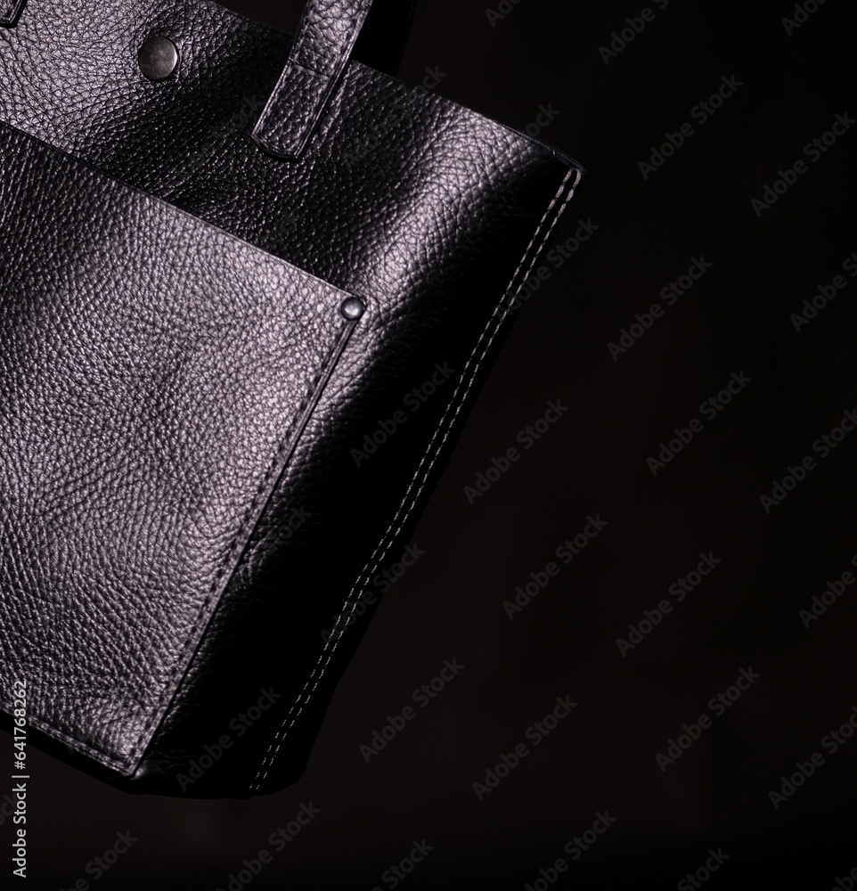 Fragment of a black leather bag on a black background Fragment of a black leather bag on a black background