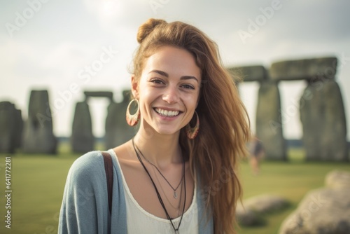 Headshot portrait photography of a cheerful girl in her 20s wearing a trendy cropped top at the stonehenge in wiltshire england. With generative AI technology