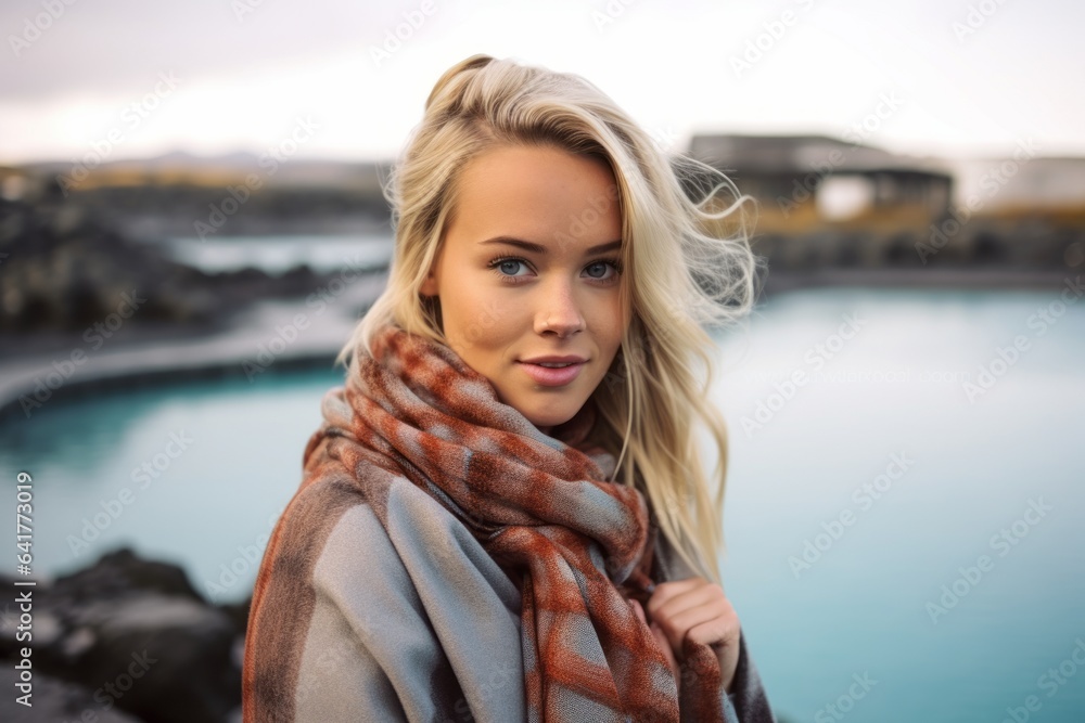 Lifestyle portrait photography of a glad girl in her 20s wearing a gorgeous silk scarf at the blue lagoon in reykjavik iceland. With generative AI technology - obrazy, fototapety, plakaty 