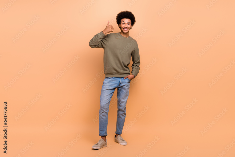 Fototapeta premium Full size photo of cheerful satisfied guy with afro hairstyle wear khaki shirt showing like good job isolated on beige color background