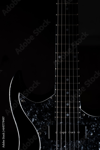 Canvas Print close up look of a black electric guitar isolated on black background