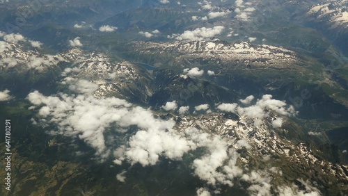 Aerial View of the Alps Covered in Snow and Clouds Seen From Airplane photo