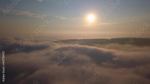 Aerial View of Flying Over Clouds at Sunrise