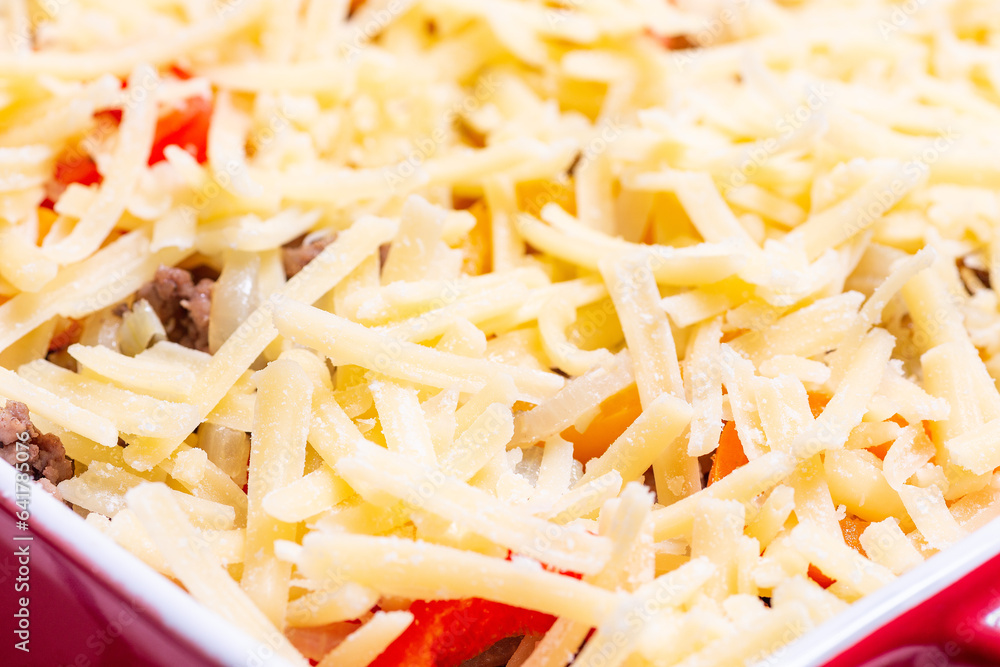 Raw casserole with potatoes, sausage and colorful bell pepper, closeup in baking dish, horizontal Raw casserole with potatoes, sausage and colorful bell pepper, closeup in baking dish, horizontal