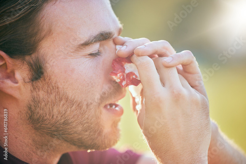 Fototapeta Naklejka Na Ścianę i Meble -  Nose bleed, man and injury closeup on sport field with emergency, accident and blood outdoor. Swollen, broken and male athlete with medical and bruise after pain, game workout and exercise training