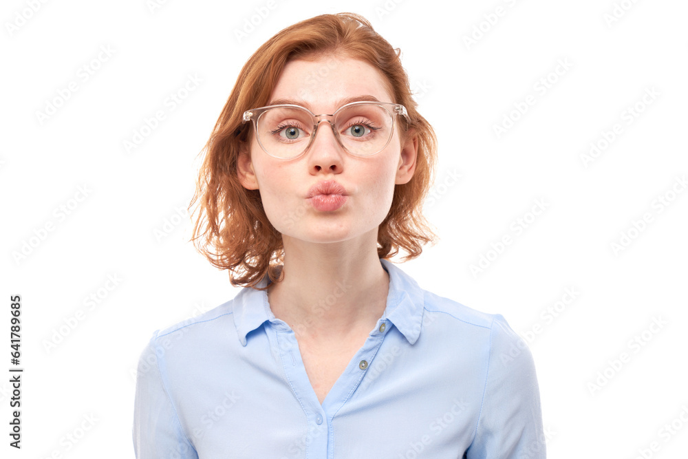 Portrait of young beautiful woman with red hair sending air kisses isolated on white studio background.
