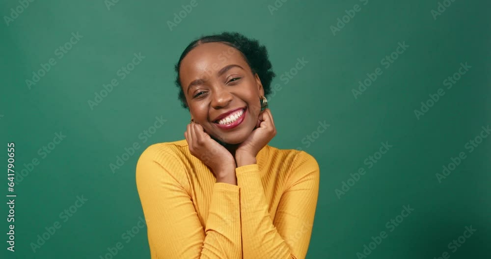 Beautiful Black woman cups hands under chin in cute pose, green studio Beautiful Black woman cups hands under chin in cute pose, green studio