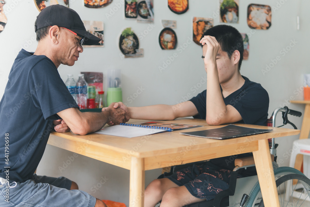 Parent hold hand of Teenage boy with disability in the restaurant ...