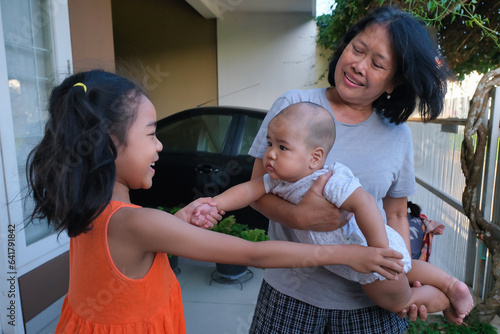 A mother playing with her daughter and baby boy photo