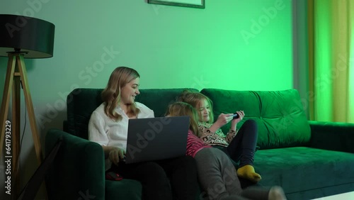 a young woman works at home, the children run into the frame and have fun, distracting the mother from work
