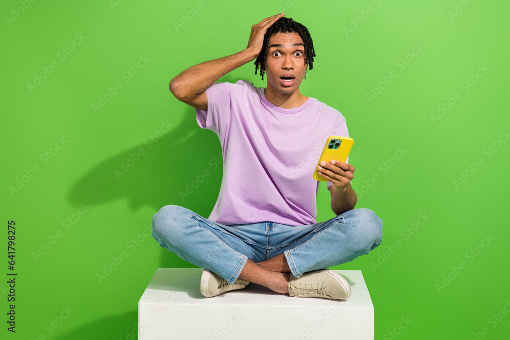 Photo of shocked impressed man dressed purple t-shirt reading news modern gadget isolated green color background Photo of shocked impressed man dressed purple t-shirt reading news modern gadget isolated green color background