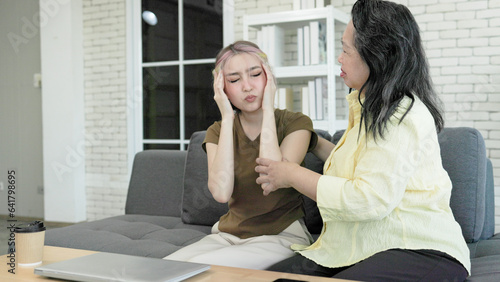 Mother comforting Asian daughter with headache stress from hard work, Young Asian woman stressed and headache from hard work and long time using computer