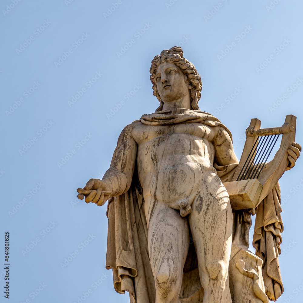 Apollo marble statue, the ancient Greek god of Fine Arts isolated on a plain sky background. Travel to Athens, Greece.
