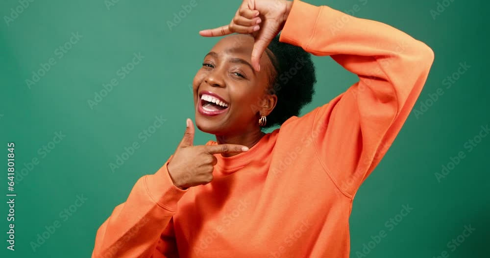 Beautiful Black woman frames face with fingers, reveals laughing portrait, studio Beautiful Black woman frames face with fingers, reveals laughing portrait, studio