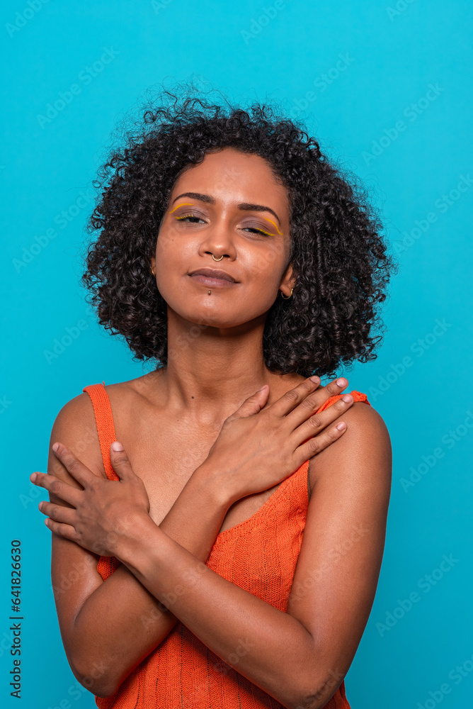 Smiling black woman in orange top looking at camera