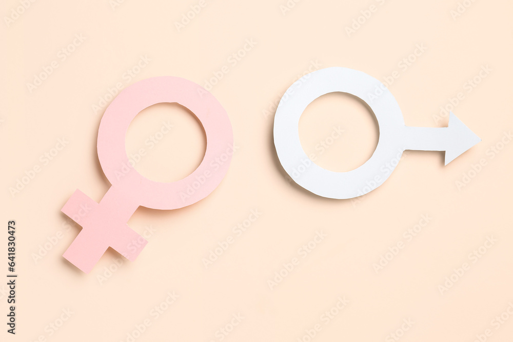 Paper symbols of female and male on pale orange background Paper symbols of female and male on pale orange background