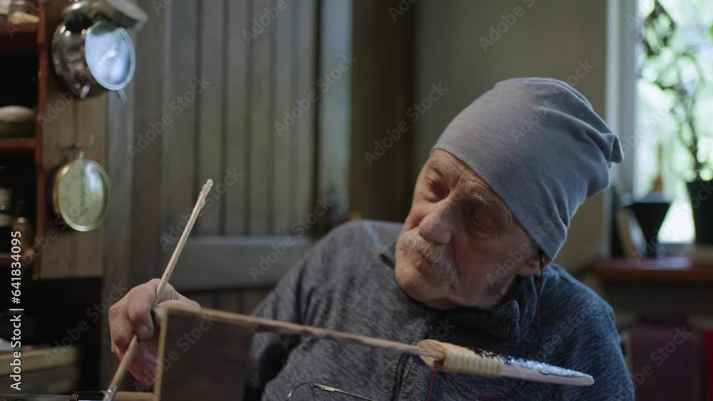 Elderly male master works in his restoring japanese deba knife