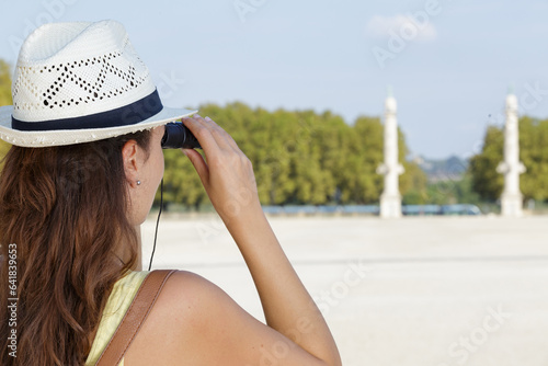 portrait of a woman looking through binoculars outdoors