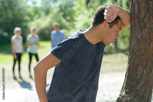 Quadro em tela sportsman leaning on tree to get his breath back