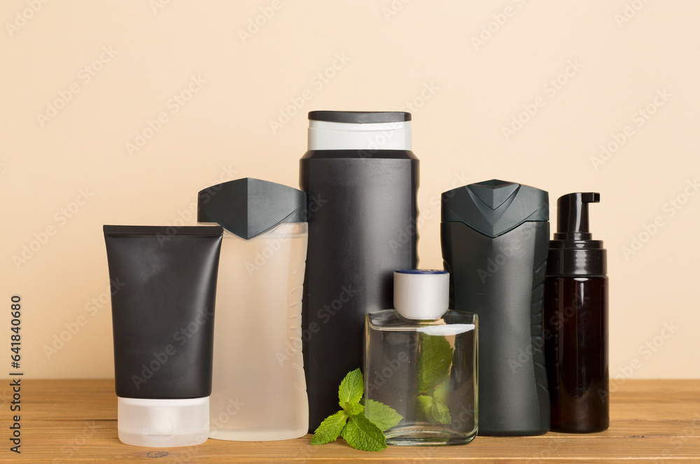 Men cosmetic bottles with mint leaves on table Men cosmetic bottles with mint leaves on table