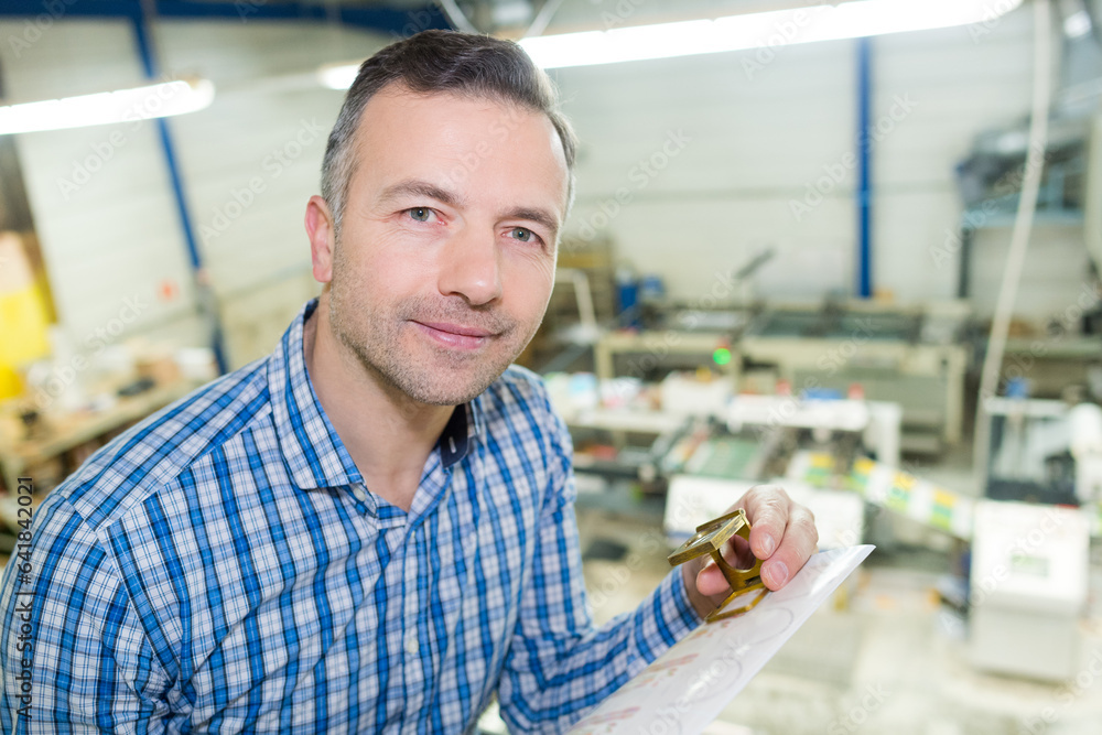 Obraz premium worker holding bolts and coil in a factory