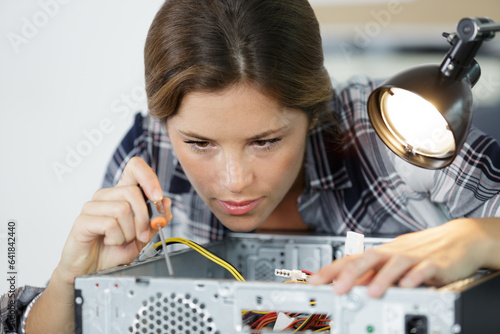 young woman fix pc component in service center