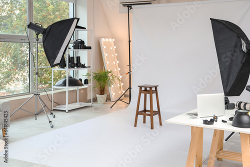 Interior of photo studio with equipment and stool