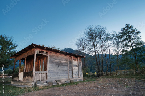 Old wooden hut with evening blue sky background © Luka