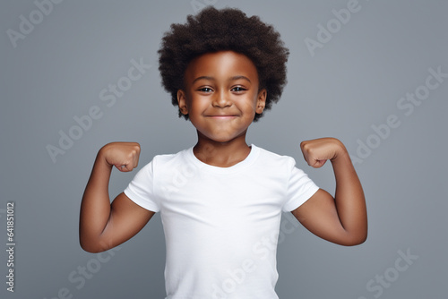 Proud DarkSkinned Boy Flexing Muscles in White TShirt and Short Afro Hairdo