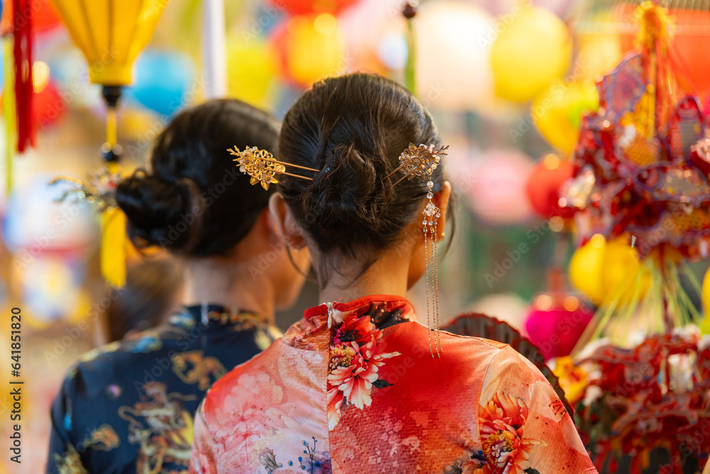 People in front of traditional colorful lanterns hanging on a stand in the streets of Cholon in Ho Chi Minh City, Vietnam during Mid Autumn Festival. Joyful and happy. People in front of traditional colorful lanterns hanging on a stand in the streets of Cholon in Ho Chi Minh City, Vietnam during Mid Autumn Festival. Joyful and happy.