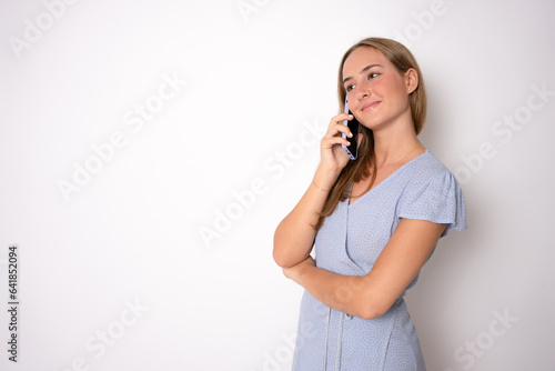 Closeup portrait of young, happy beautiful woman talking on cell phone looking away, over white background