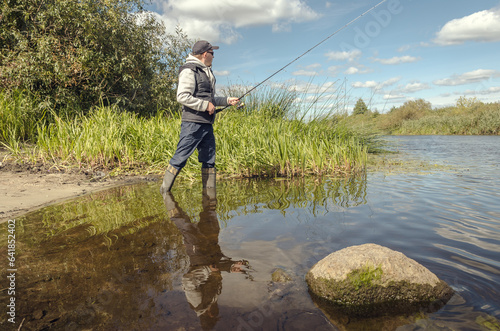 Man catching fish, pulling rod while fishing.