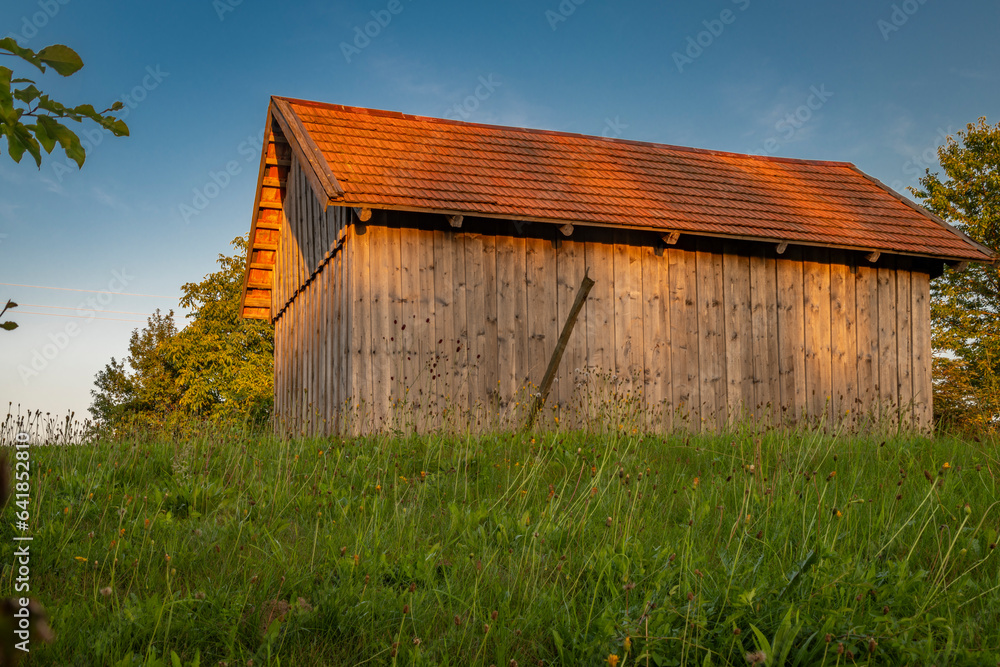 Old wooden barn with sunset colors and blue sky in Krkonose mountains Old wooden barn with sunset colors and blue sky in Krkonose mountains