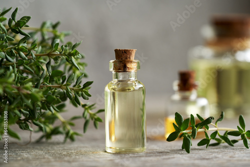 Foto A bottle of thyme essential oil with fresh thyme
