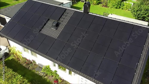 Drone circling over villa with solar panels and electric car charging