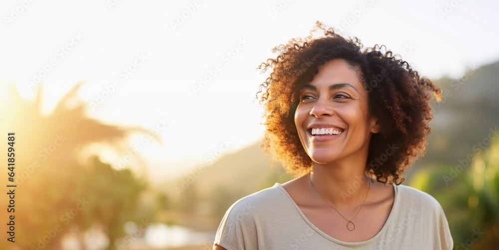 Lifestyle portrait of happy black woman with curly hair on vacation walking on tropical island beach at sunset - obrazy, fototapety, plakaty 