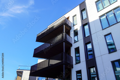 Look up to white appartment building with balconies towards blue sky. Kalamaja, Tallinn, Estonia