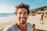 Happy young caucasian man enjoying a day on the beach while smiling and making a picture