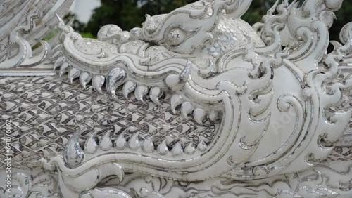 Detail of a dragon's mouth at Wat Rong Khun - White Temple in Chiang Rai, Thailand